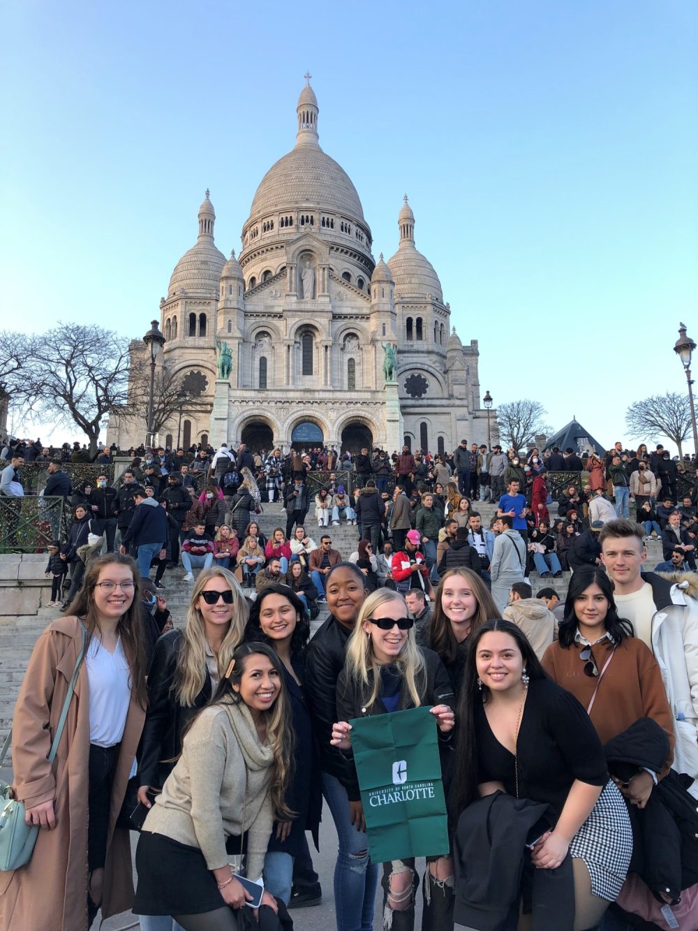 A group of Charlotte students posing for a picture in front of a popular tourist destination in France.